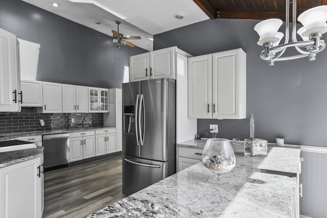 kitchen featuring stainless steel appliances, white cabinets, and ceiling fan with notable chandelier