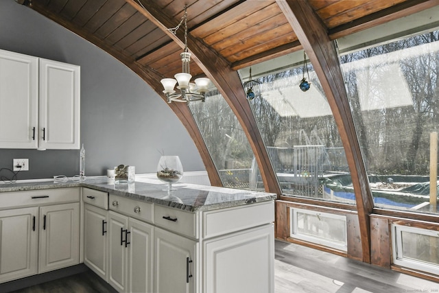 kitchen featuring wooden ceiling, white cabinets, a peninsula, and stone countertops