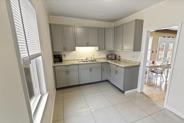 kitchen featuring a sink, light tile patterned floors, gray cabinets, and crown molding