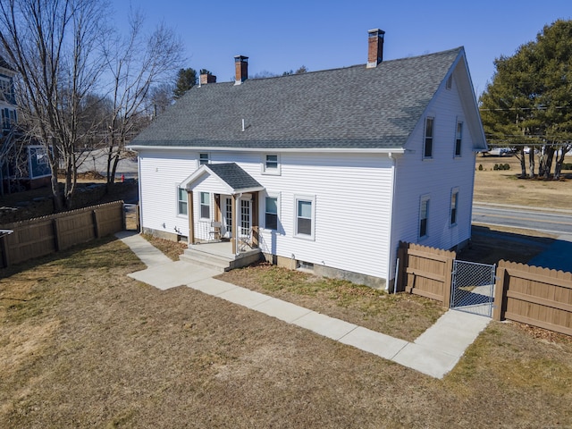 view of front of property with a front lawn, fence, roof with shingles, a chimney, and a gate