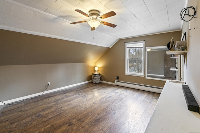 additional living space featuring wood finished floors, lofted ceiling, baseboards, and a baseboard radiator