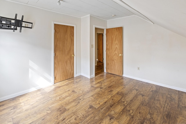 interior space featuring crown molding, baseboards, and wood-type flooring