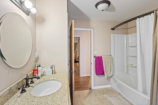 bathroom with vanity, tile patterned floors, baseboards, and shower / bath combo with shower curtain