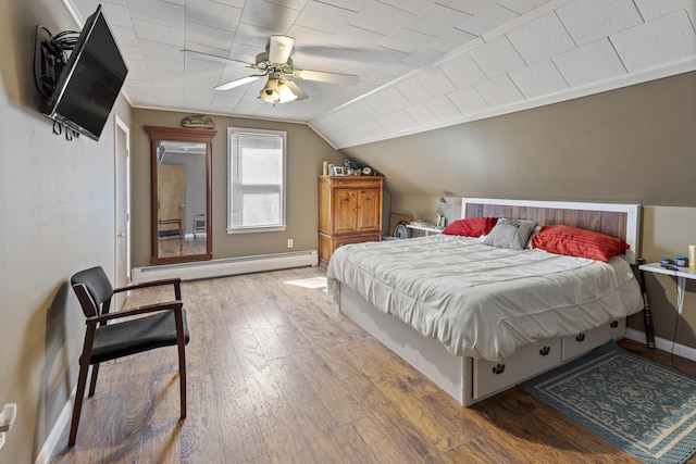 bedroom with baseboards, ceiling fan, hardwood / wood-style flooring, vaulted ceiling, and a baseboard heating unit