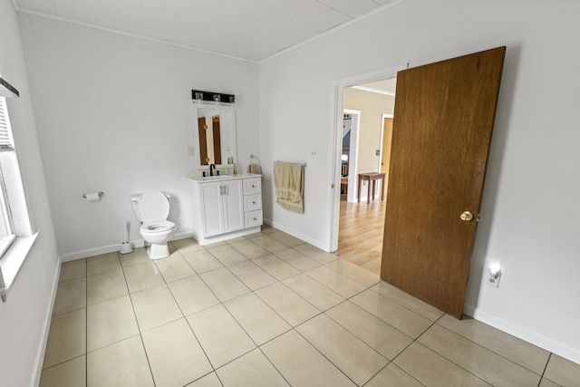 bathroom with vanity, baseboards, ornamental molding, tile patterned flooring, and toilet