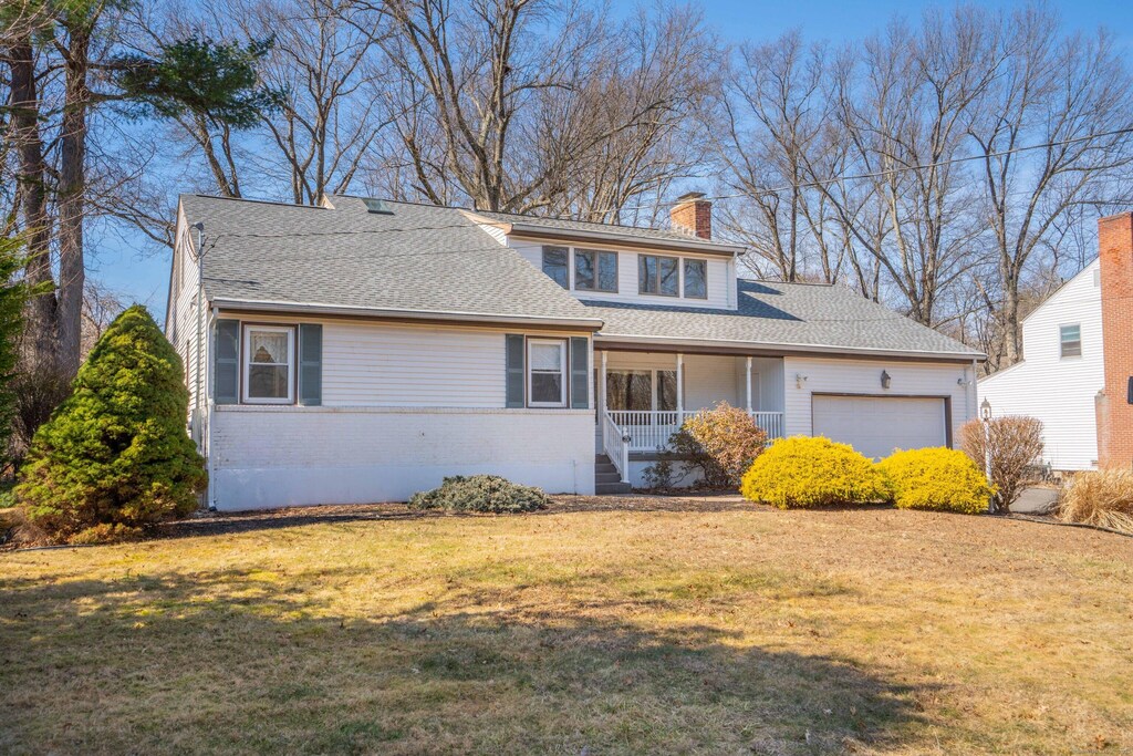 251 King Philip Dr, West Hartford, CT 06117 - traditional home with roof with shingles, a chimney, a front lawn, a garage, and brick siding