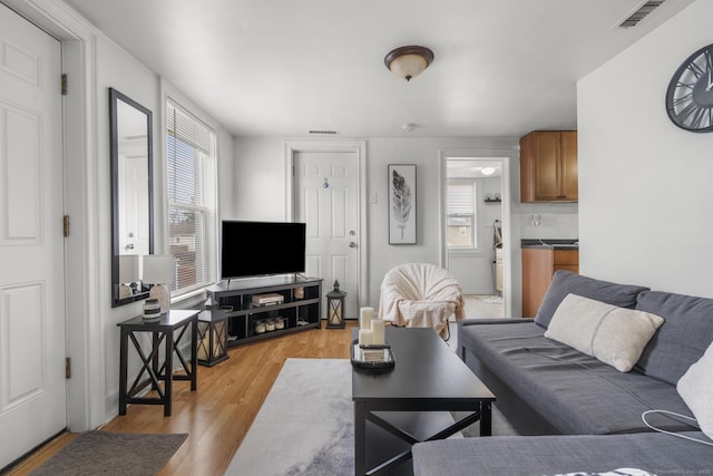 living room featuring light wood-type flooring and visible vents