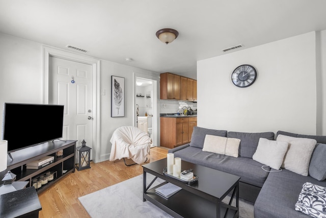 living room with visible vents and light wood-style flooring