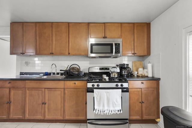 kitchen with a sink, appliances with stainless steel finishes, and brown cabinetry