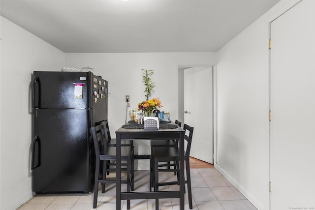 dining space featuring light tile patterned floors and baseboards