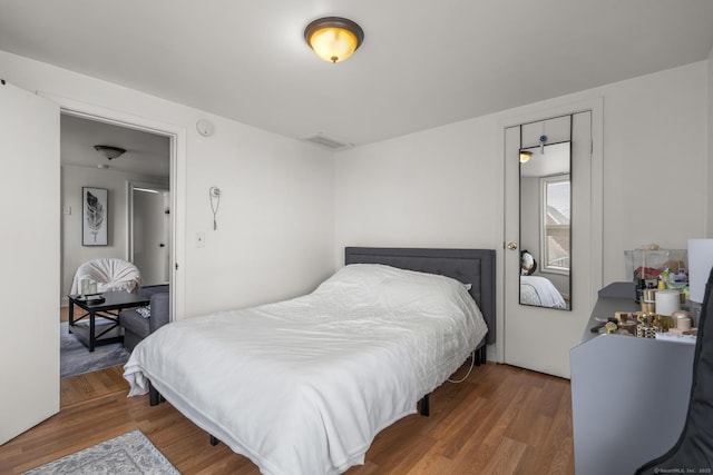 bedroom featuring wood finished floors and visible vents