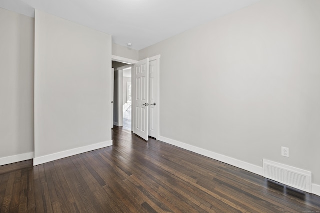 unfurnished bedroom featuring visible vents, baseboards, and dark wood-style flooring