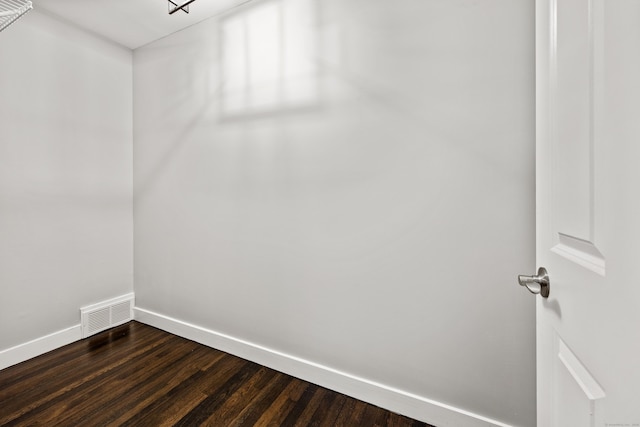 empty room with visible vents, baseboards, and dark wood-style floors