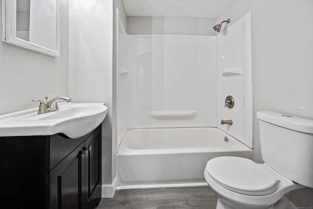 full bathroom with washtub / shower combination, toilet, vanity, and wood finished floors