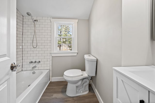 bathroom featuring wood finished floors, baseboards, lofted ceiling, bathtub / shower combination, and toilet