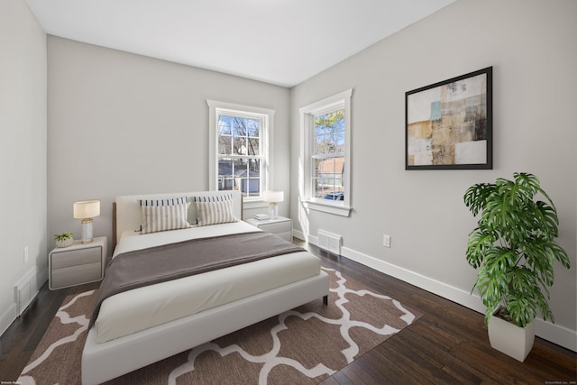 bedroom featuring visible vents, baseboards, and wood finished floors