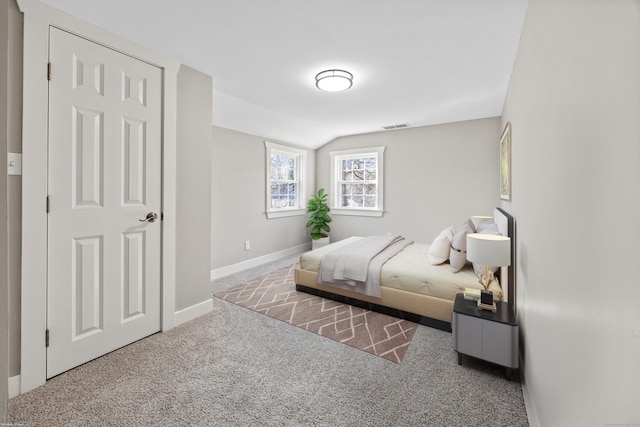 bedroom with visible vents, carpet floors, baseboards, and vaulted ceiling