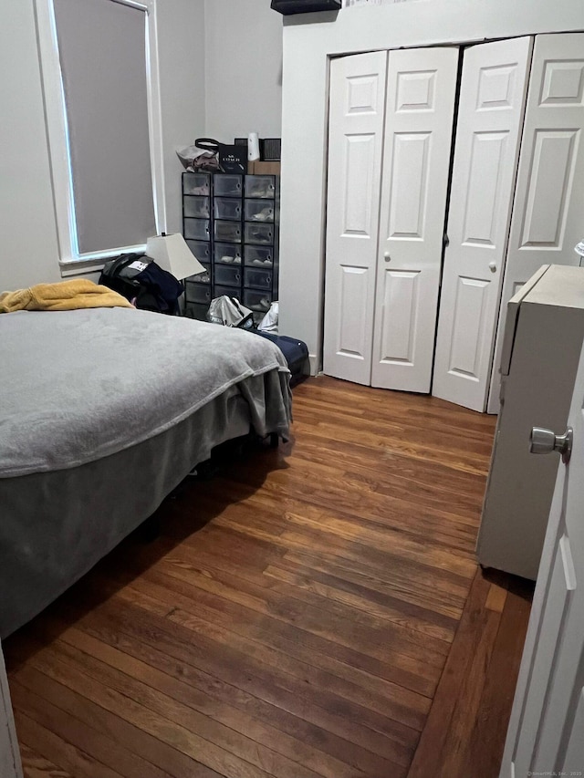 bedroom featuring dark wood-style flooring and a closet