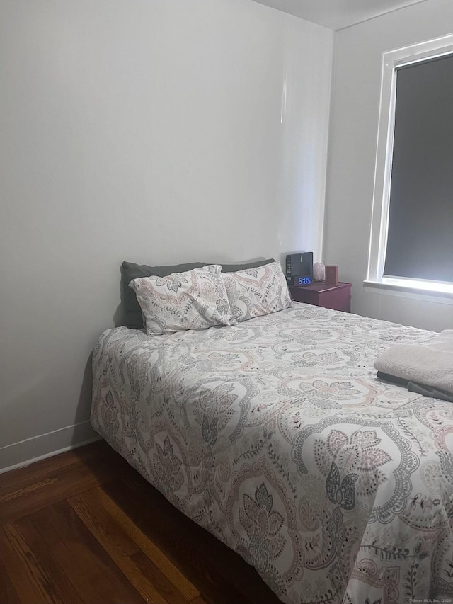 bedroom featuring baseboards and wood finished floors