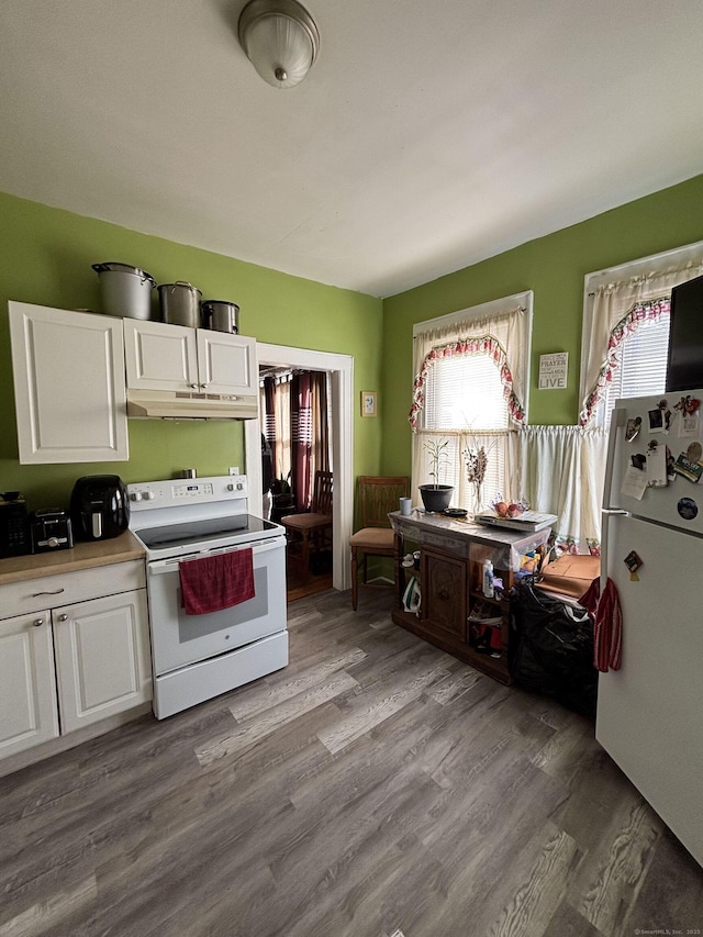 kitchen featuring under cabinet range hood, light countertops, wood finished floors, white cabinets, and white appliances