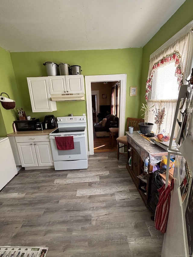 kitchen featuring dark wood finished floors, light countertops, under cabinet range hood, white cabinetry, and white range with electric stovetop