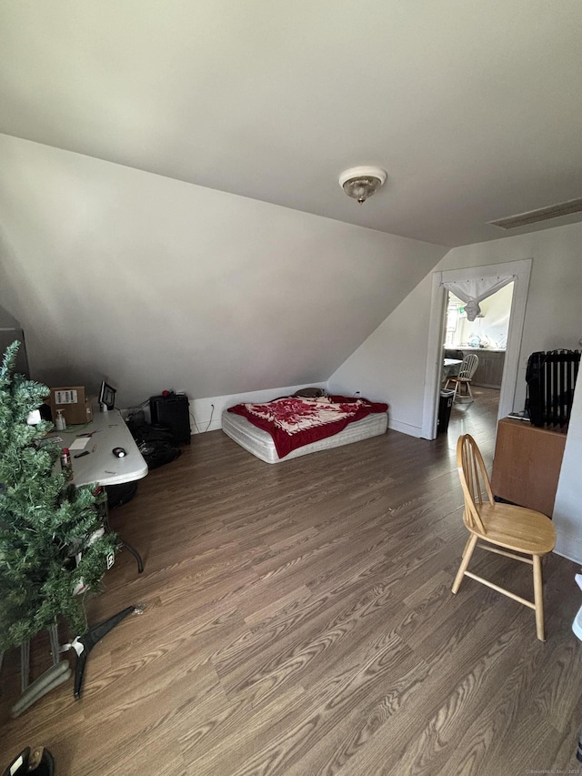 bonus room with visible vents, wood finished floors, and vaulted ceiling