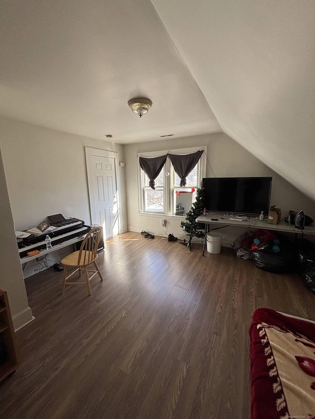 interior space featuring vaulted ceiling, baseboards, and wood finished floors