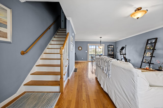 living room with visible vents, ornamental molding, stairway, light wood finished floors, and baseboards