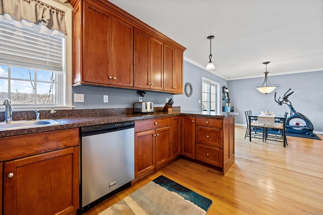 kitchen featuring a sink, brown cabinets, light wood-type flooring, and stainless steel dishwasher