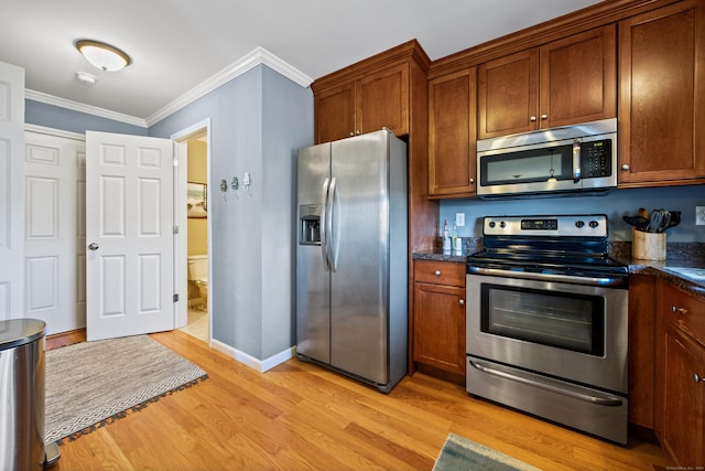 kitchen with brown cabinets, light wood-style floors, appliances with stainless steel finishes, and crown molding