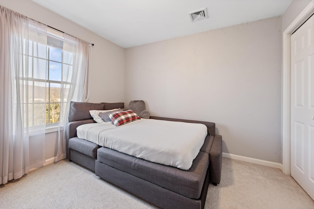 bedroom featuring light carpet, visible vents, and baseboards