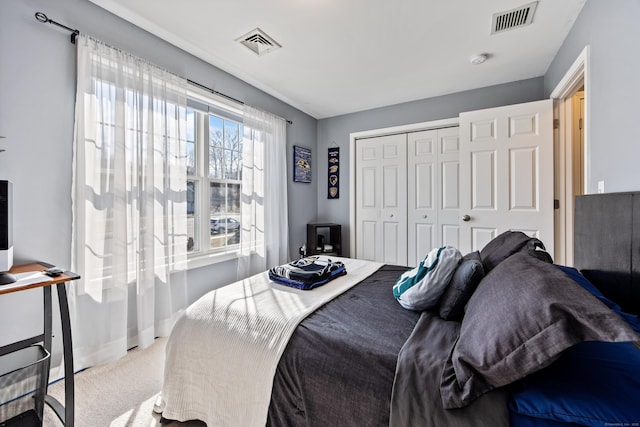 bedroom with baseboards, visible vents, carpet floors, and a closet