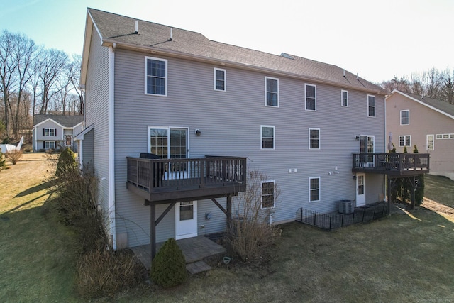 back of house featuring a yard, central AC, and a wooden deck