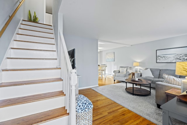 stairs with wood finished floors and a baseboard radiator