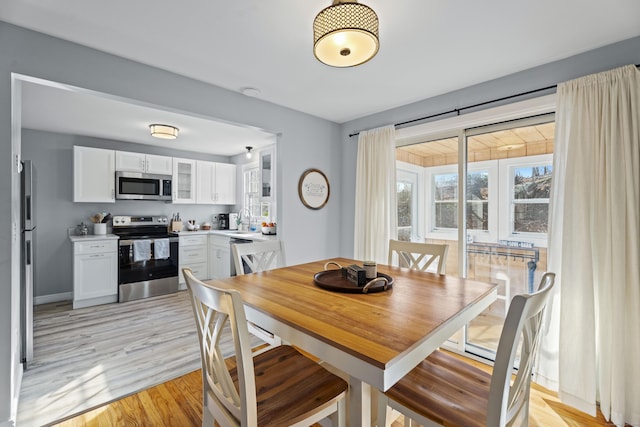 dining space featuring plenty of natural light and light wood-style floors