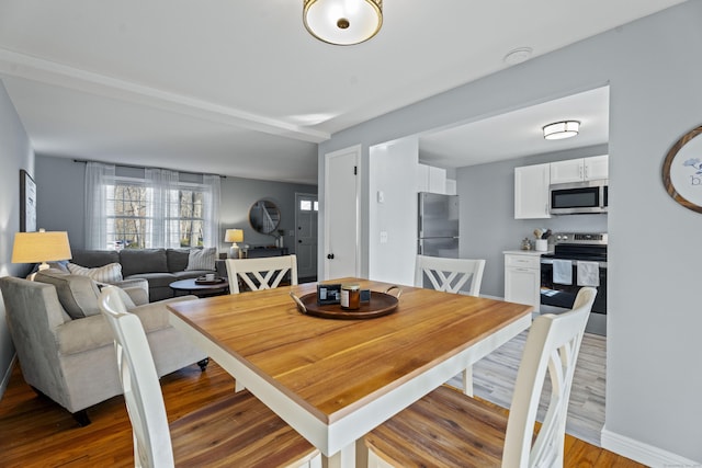 dining space featuring wood finished floors and baseboards