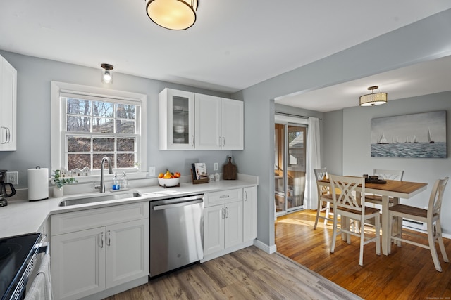 kitchen featuring a healthy amount of sunlight, appliances with stainless steel finishes, white cabinets, and a sink