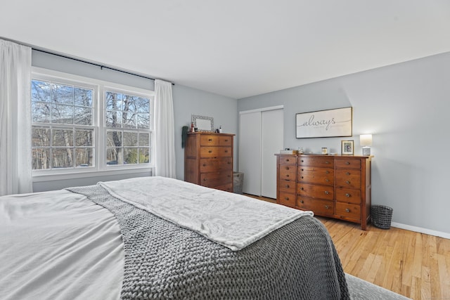 bedroom featuring a closet, baseboards, and wood finished floors