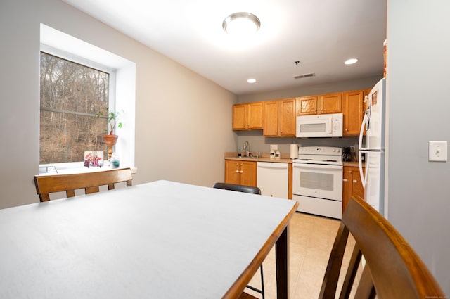 kitchen with white appliances, visible vents, recessed lighting, a sink, and light countertops