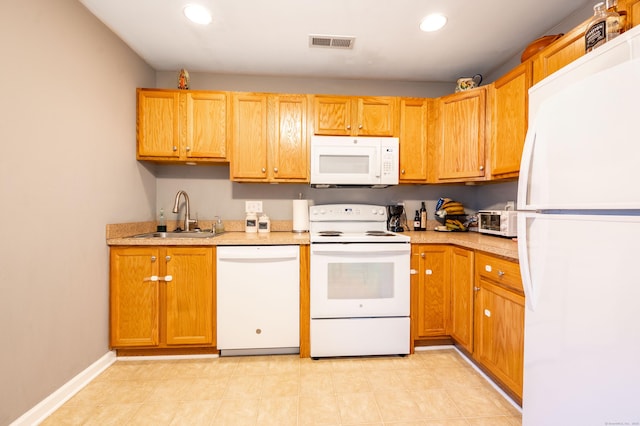 kitchen with visible vents, light countertops, recessed lighting, white appliances, and a sink