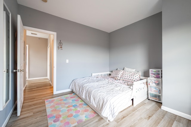 bedroom featuring wood finished floors and baseboards