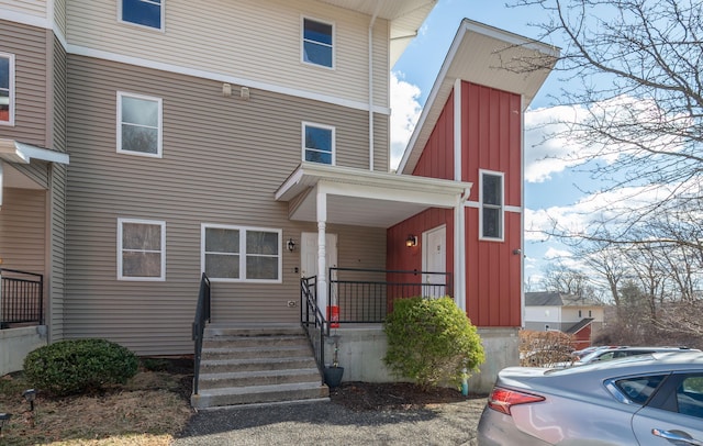 american foursquare style home featuring covered porch and board and batten siding