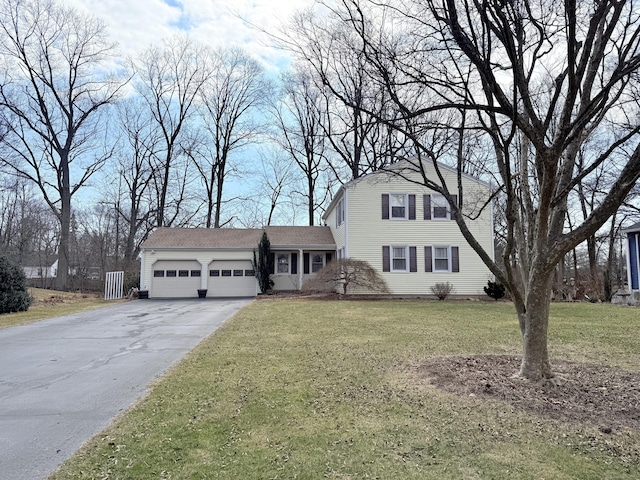 view of front of home with a garage, a front lawn, and driveway