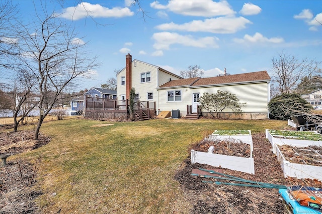 rear view of house with entry steps, a wooden deck, central AC, a yard, and a garden