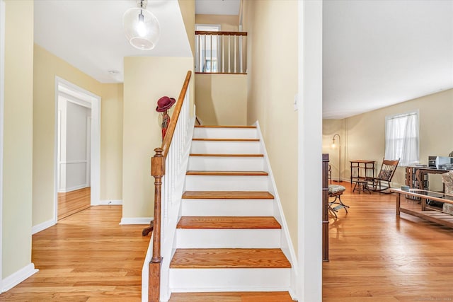 stairs with baseboards and wood finished floors