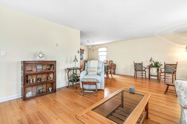 sitting room featuring baseboards, an inviting chandelier, and wood finished floors