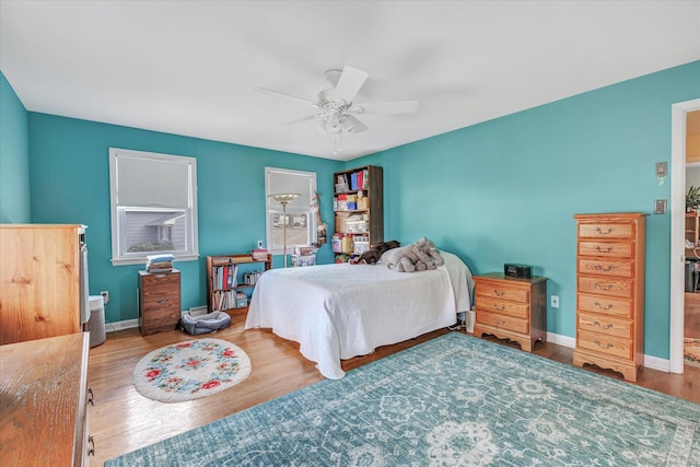 bedroom featuring a ceiling fan, wood finished floors, and baseboards