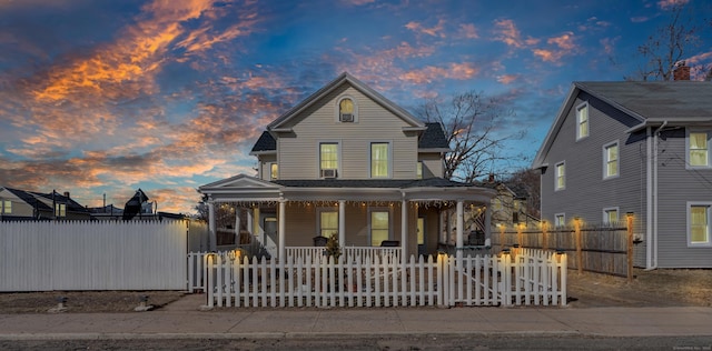 view of front of property featuring a fenced front yard, a porch, and a gate