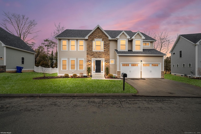 view of front of home featuring a lawn, aphalt driveway, stone siding, fence, and a garage