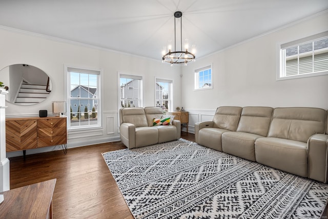 living area featuring a wainscoted wall, wood finished floors, stairs, and ornamental molding